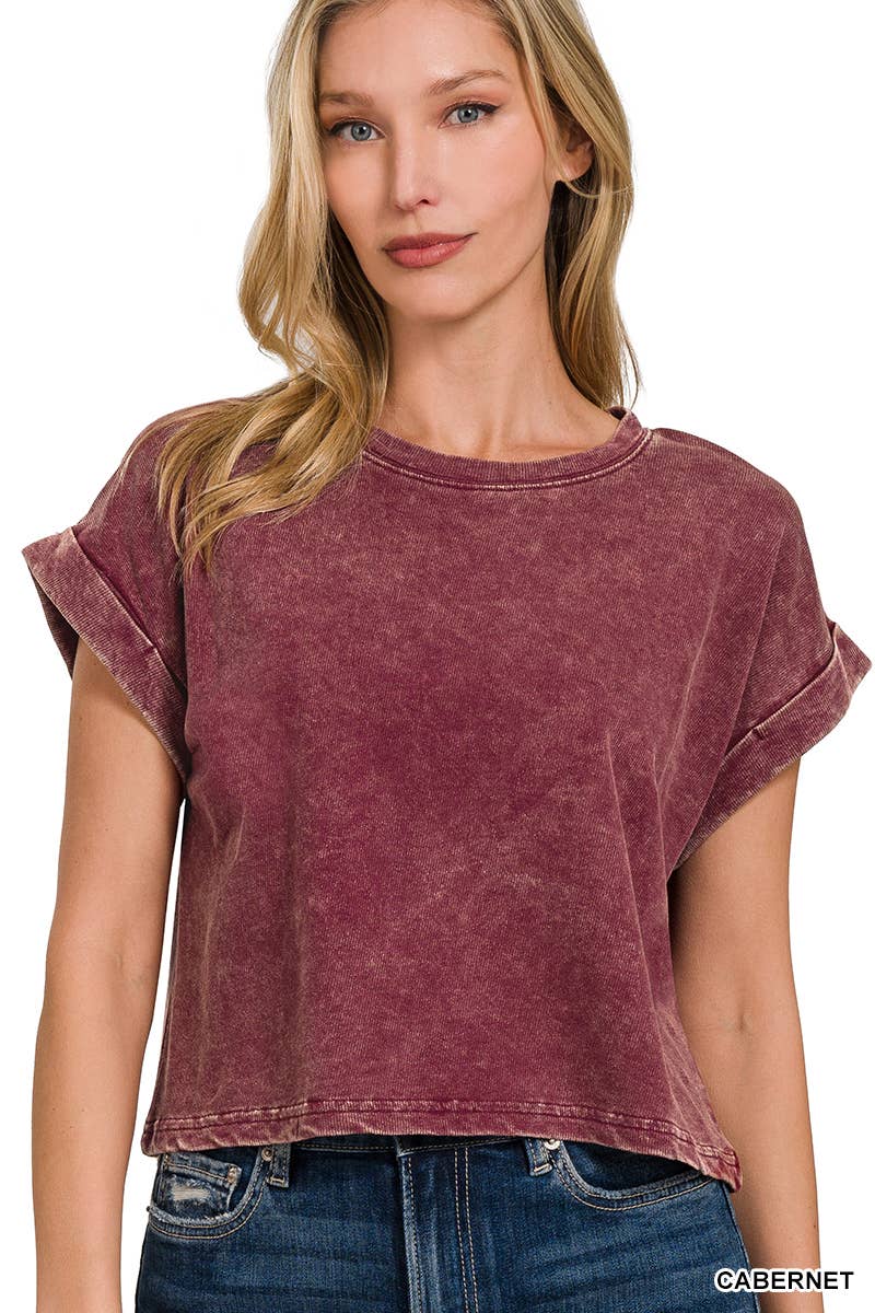 A woman wearing a lavender acid wash cotton folded sleeve top with jeans.